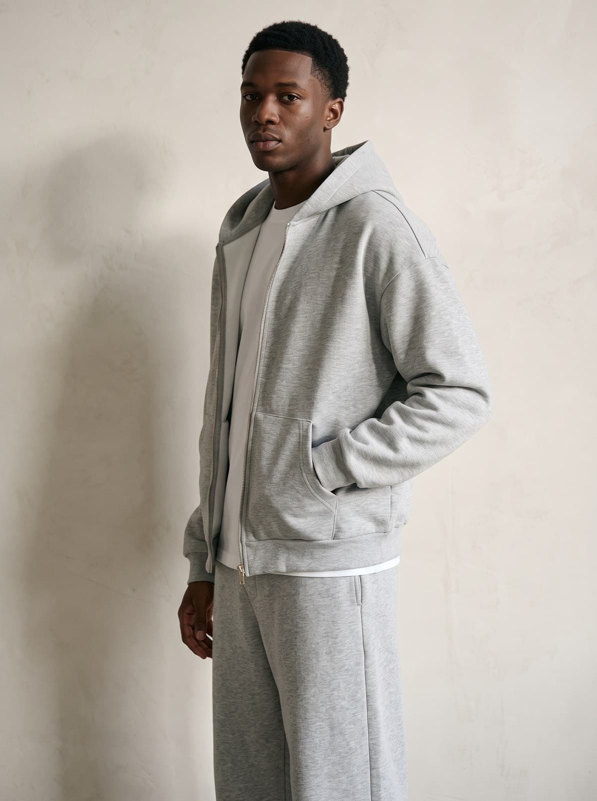 Three-quarter view of the Kensington Zip Hoodie in grey marl worn open over a tee, showing the dropped shoulder seam